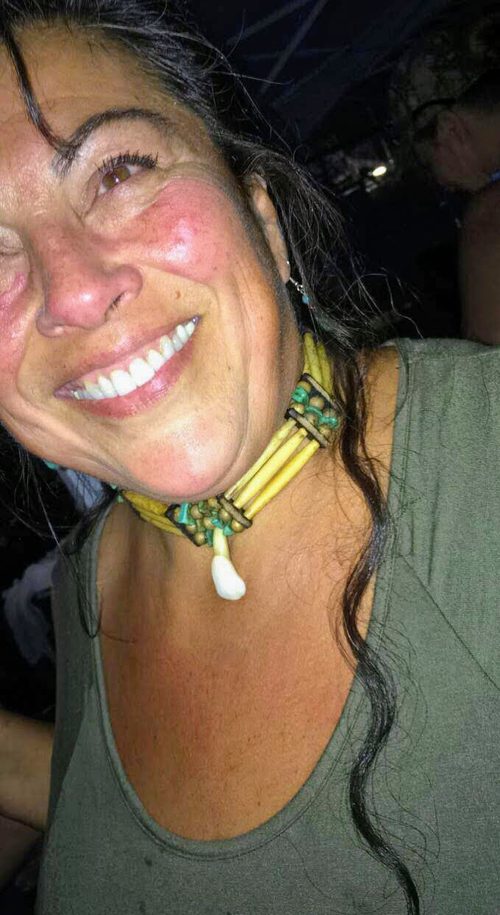 Denise laughing, hair in braids, at a night event outside the rec center